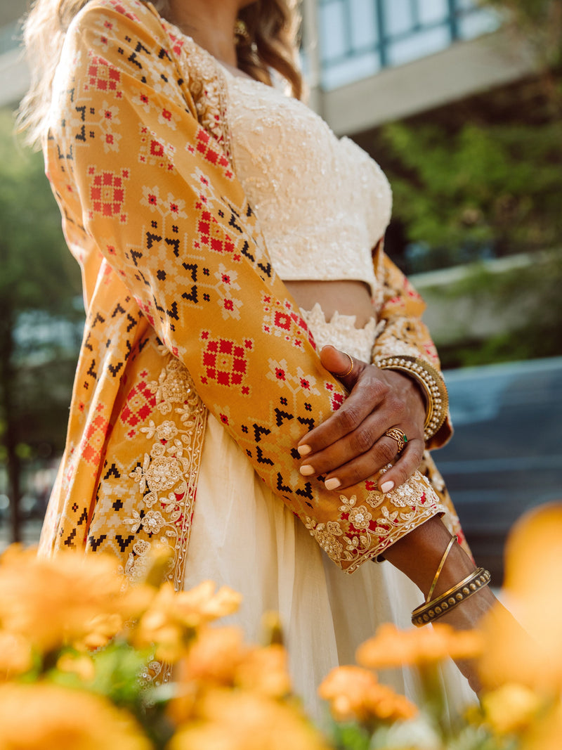 Marigold printed jacket with ivory crop top and skirt